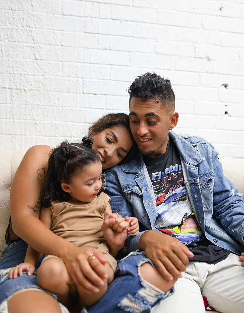 parents and daughter sitting on sofa